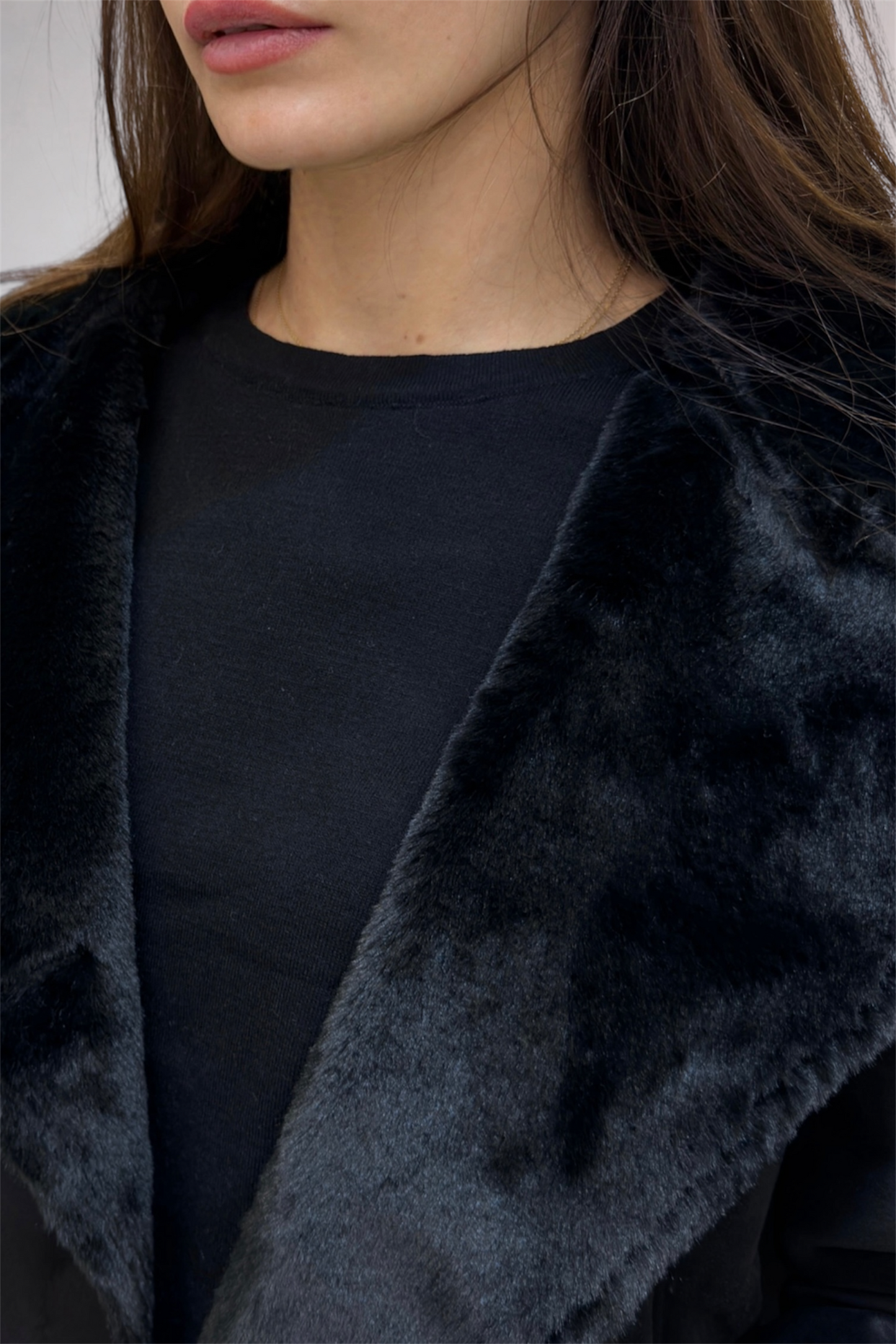 Close-up of a person wearing a dark coat with a blurred background