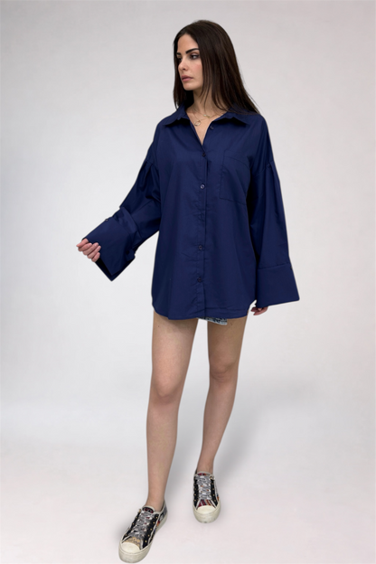 Woman wearing a navy blue oversized shirt and shorts on a white background