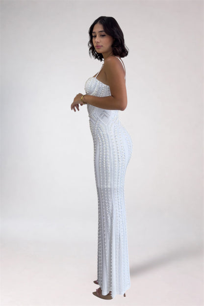 Woman wearing a white strapless dress with a pattern on a plain background