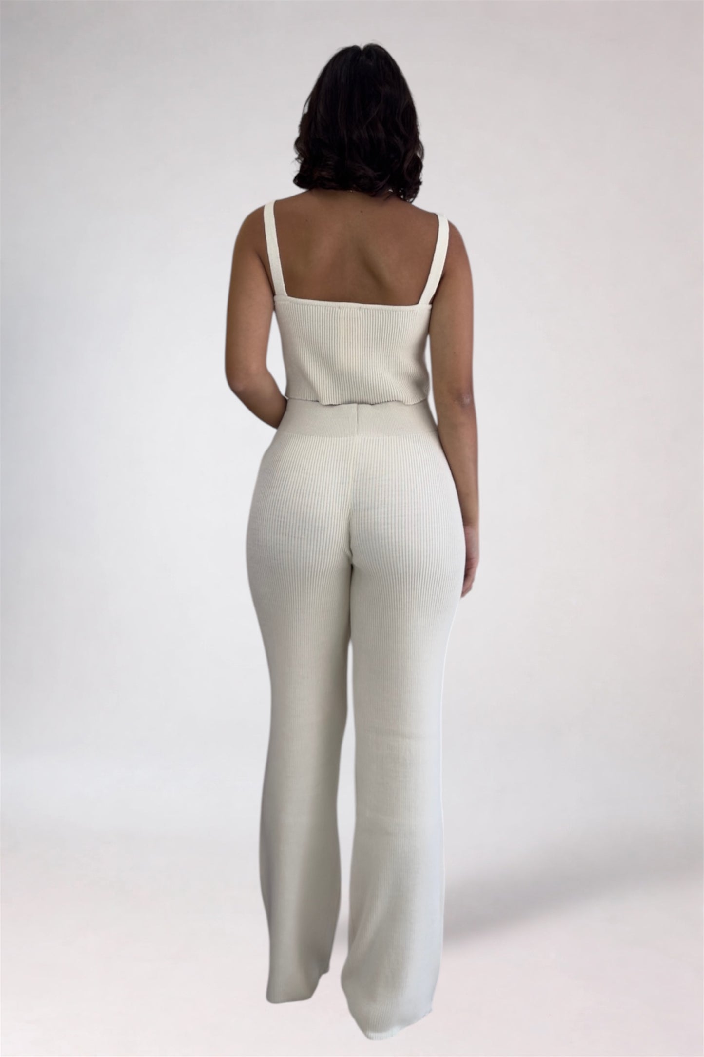 Person wearing a white jumpsuit on a plain background