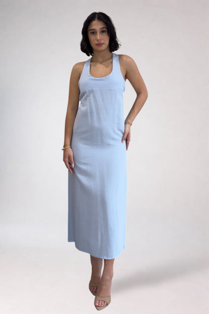 Woman wearing a light blue sleeveless dress against a white background