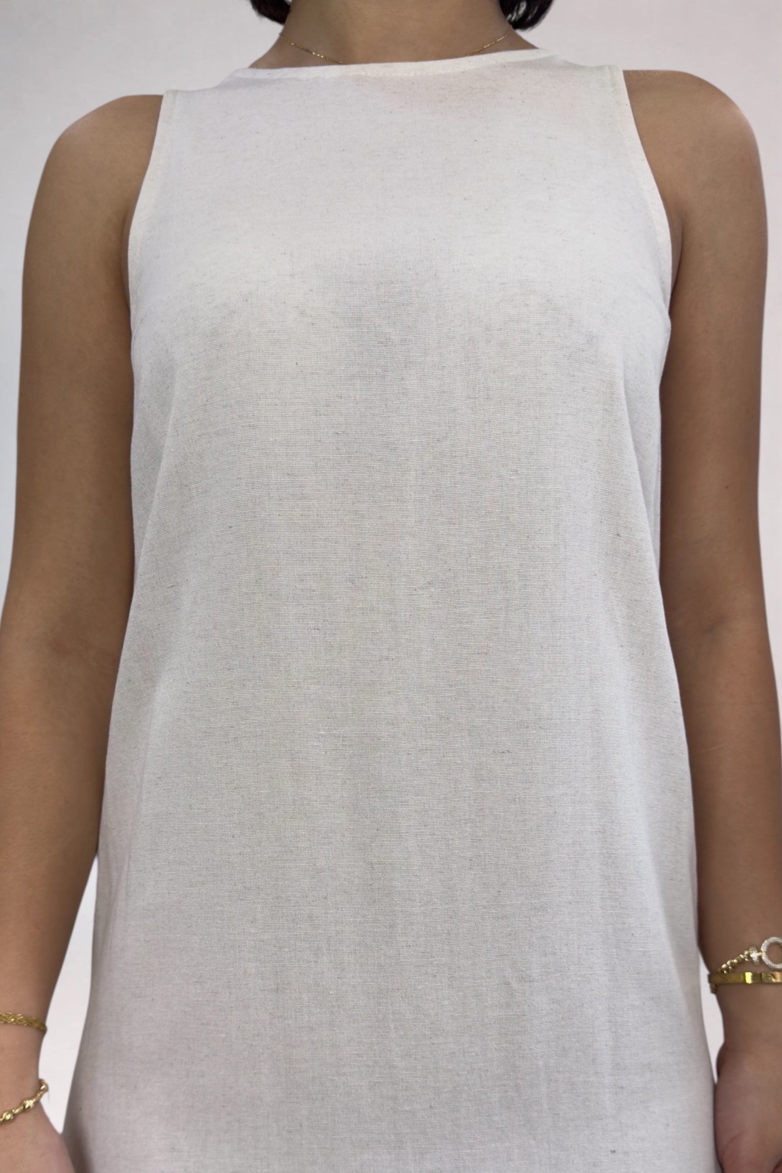 White sleeveless top worn by a person on a plain background