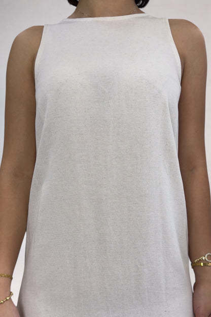 White sleeveless top worn by a person on a plain background