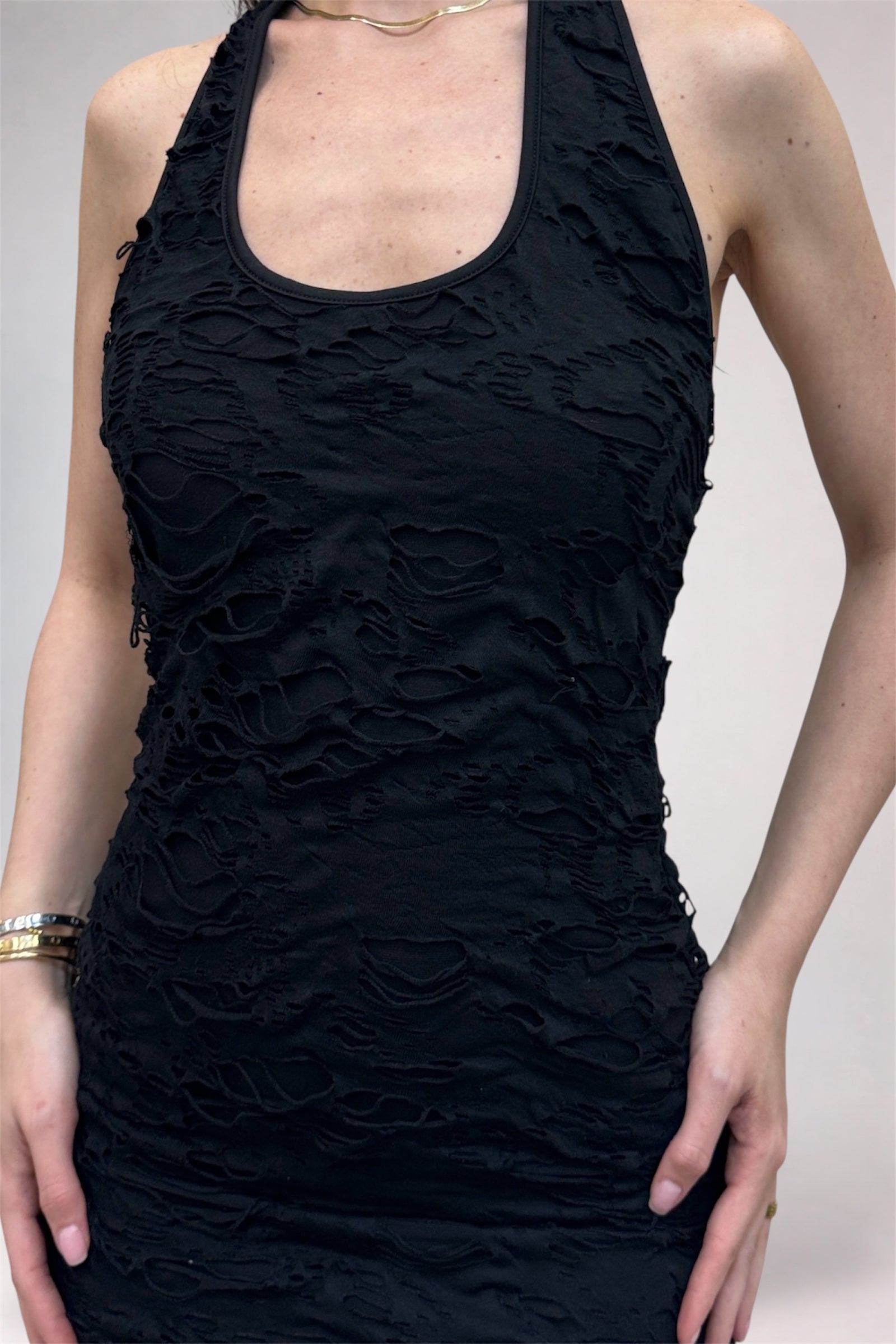 Black textured dress worn by a person on a plain background