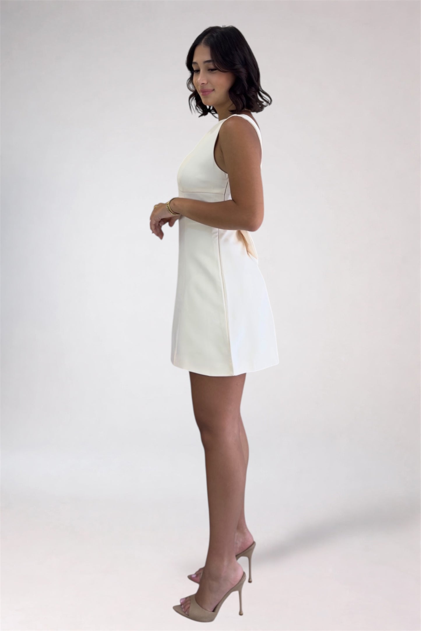 Woman wearing a white dress against a plain background