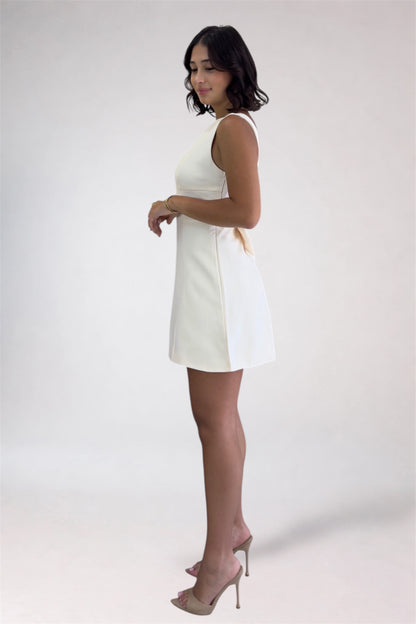 Woman wearing a white dress against a plain background