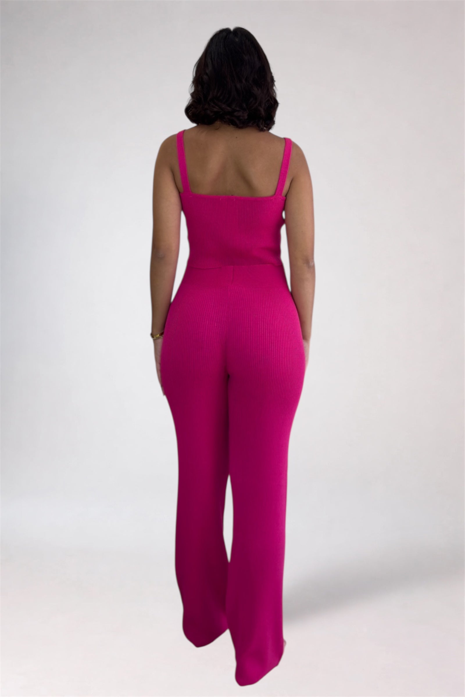 Person wearing a bright pink jumpsuit on a white background