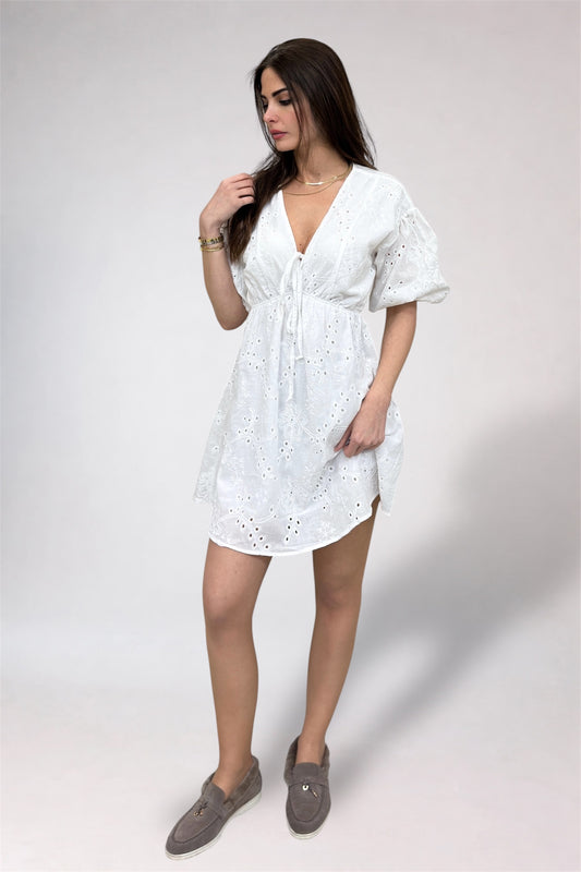Woman wearing a white dress with a plain background