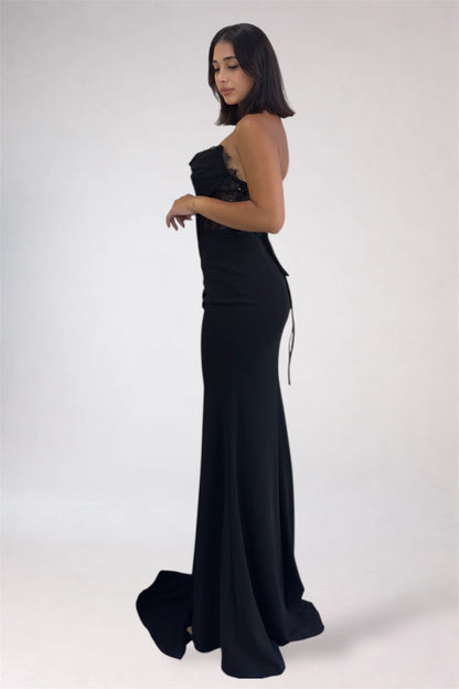 Woman wearing a black strapless gown on a white background