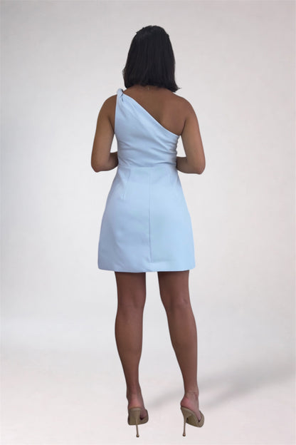 Woman wearing a light blue one-shoulder dress on a white background