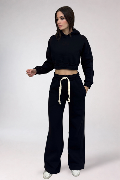 Woman wearing a black hoodie and black pants with a white drawstring on a white background