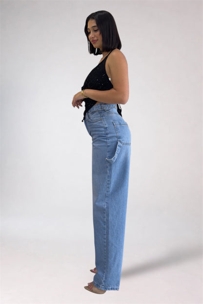 Woman wearing light blue jeans and a black top on a white background