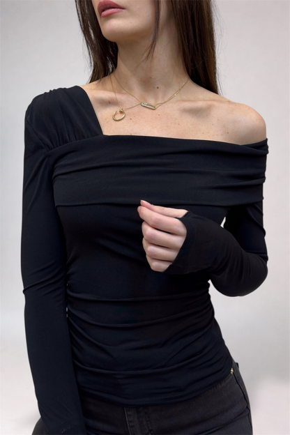 Woman wearing a black off-shoulder top against a white background