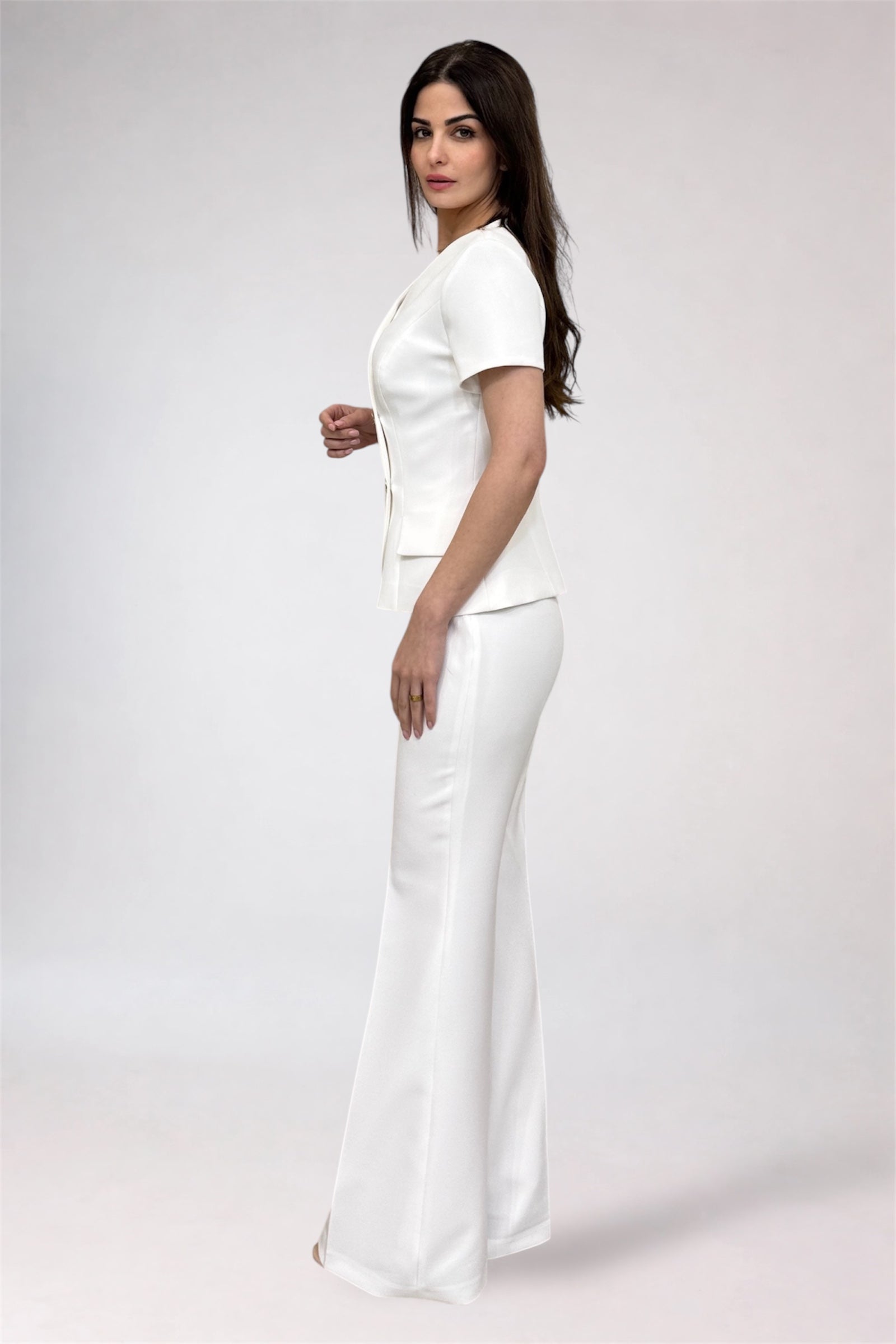 Woman wearing a white outfit on a plain background