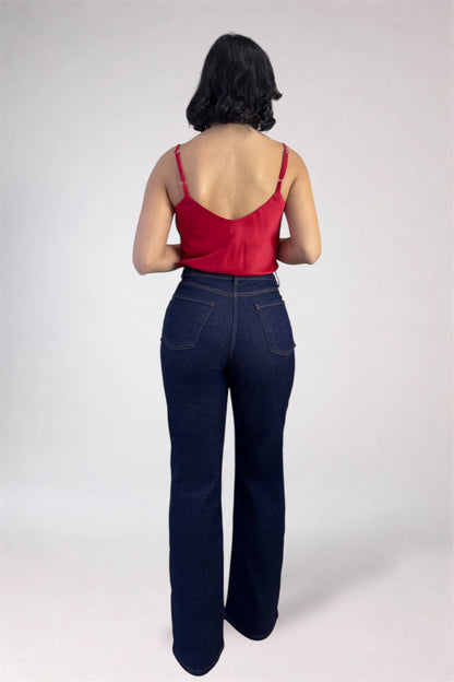 Person wearing a red top and dark blue jeans on a white background