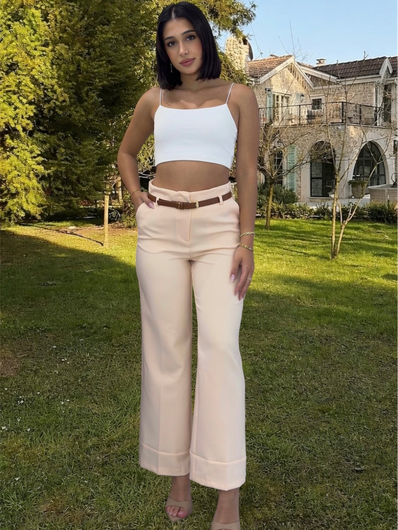 Woman wearing a light blue top and beige pants in nature 