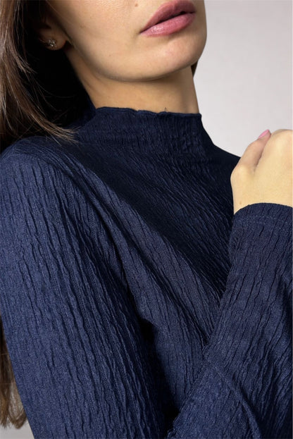 Navy blue ribbed sweater worn by a person with a neutral background