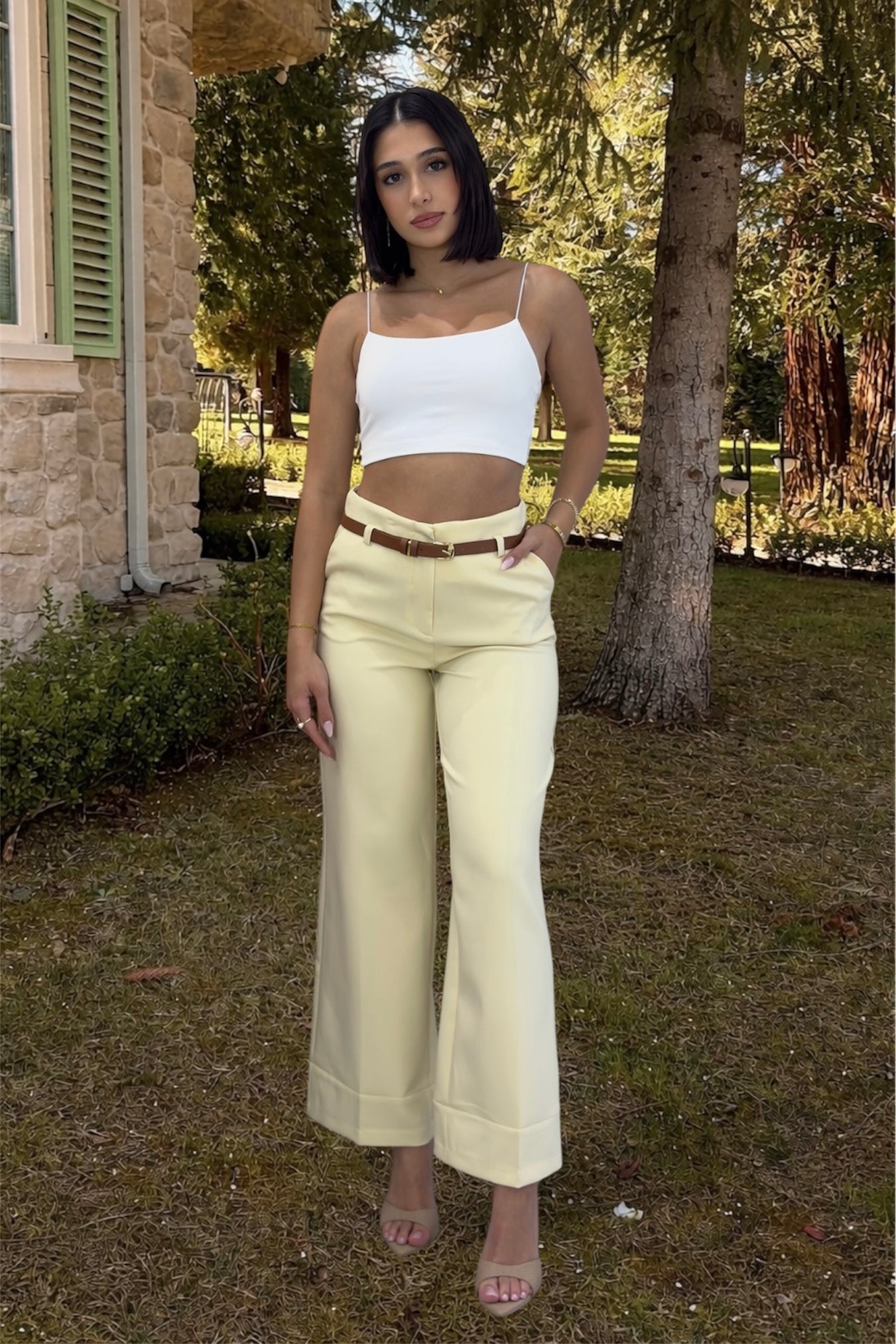 Woman wearing a white top and yellow pants in nature